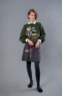 Thumbnail for Woman wearing wool sweater and skirt. A grey skirt with a colourful embroidery on the right leg. 