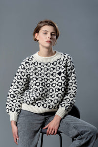 Thumbnail for Handmade wool sweater with cropped cut and puffed sleeves. On the sweater is a herd of white sheep going all around, a single black sheep is on the front top left of the sweater. 