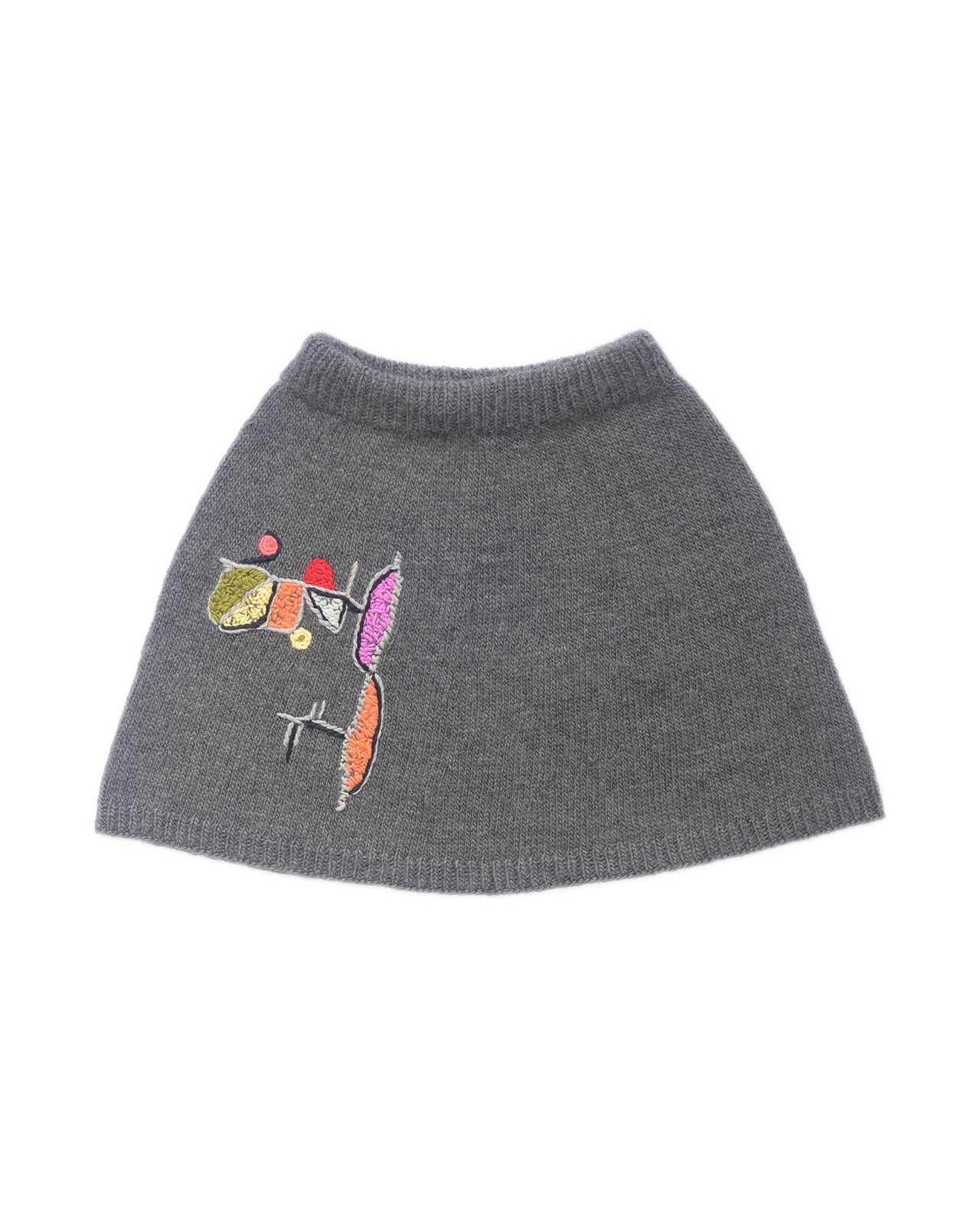 Grey wool skirt laid flat on white background. The skirt has a colourful embroidery on the right leg. 