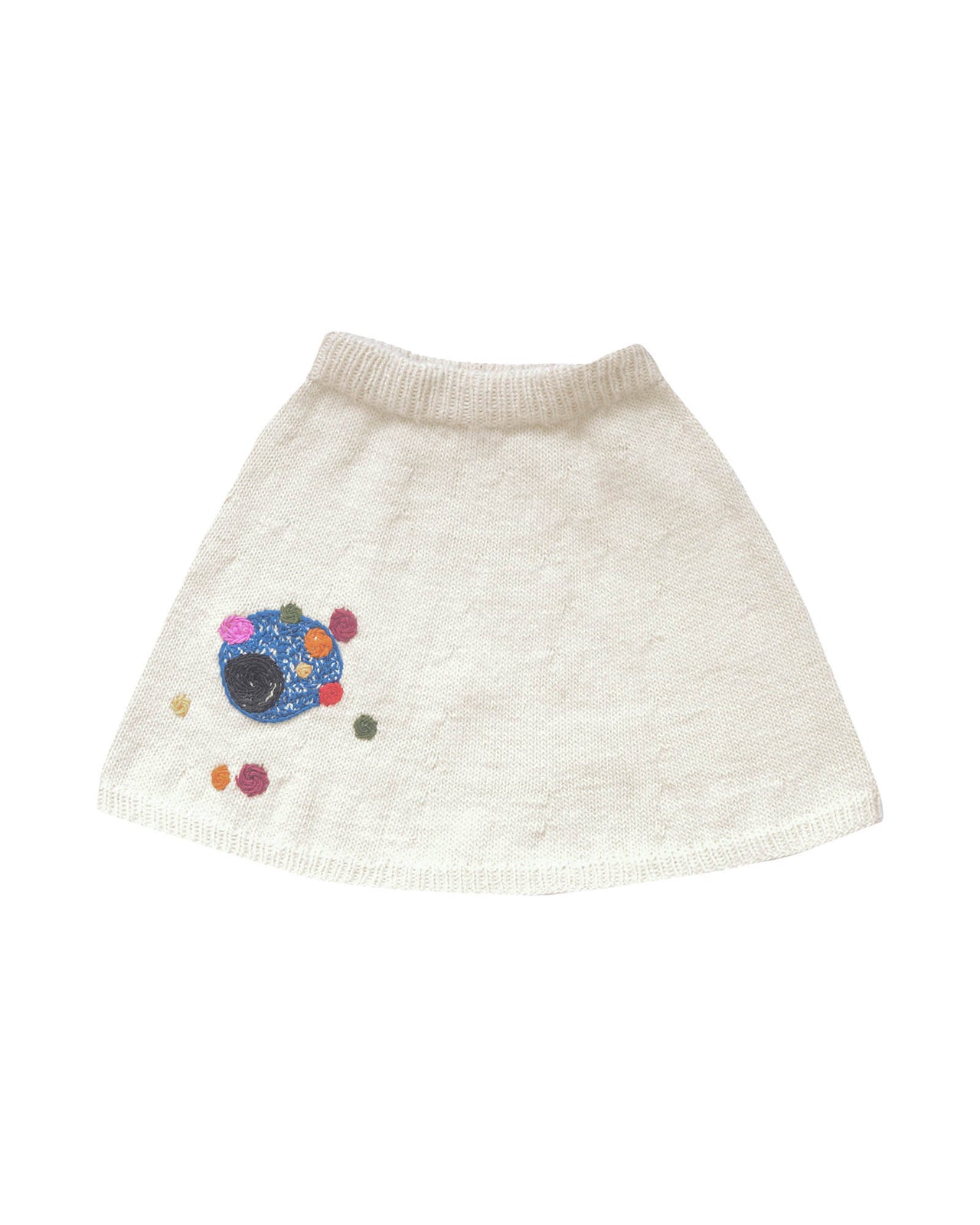 White wool skirt laid flat on white background. The skirt has colourful bubble-like embroideries on the right leg. 