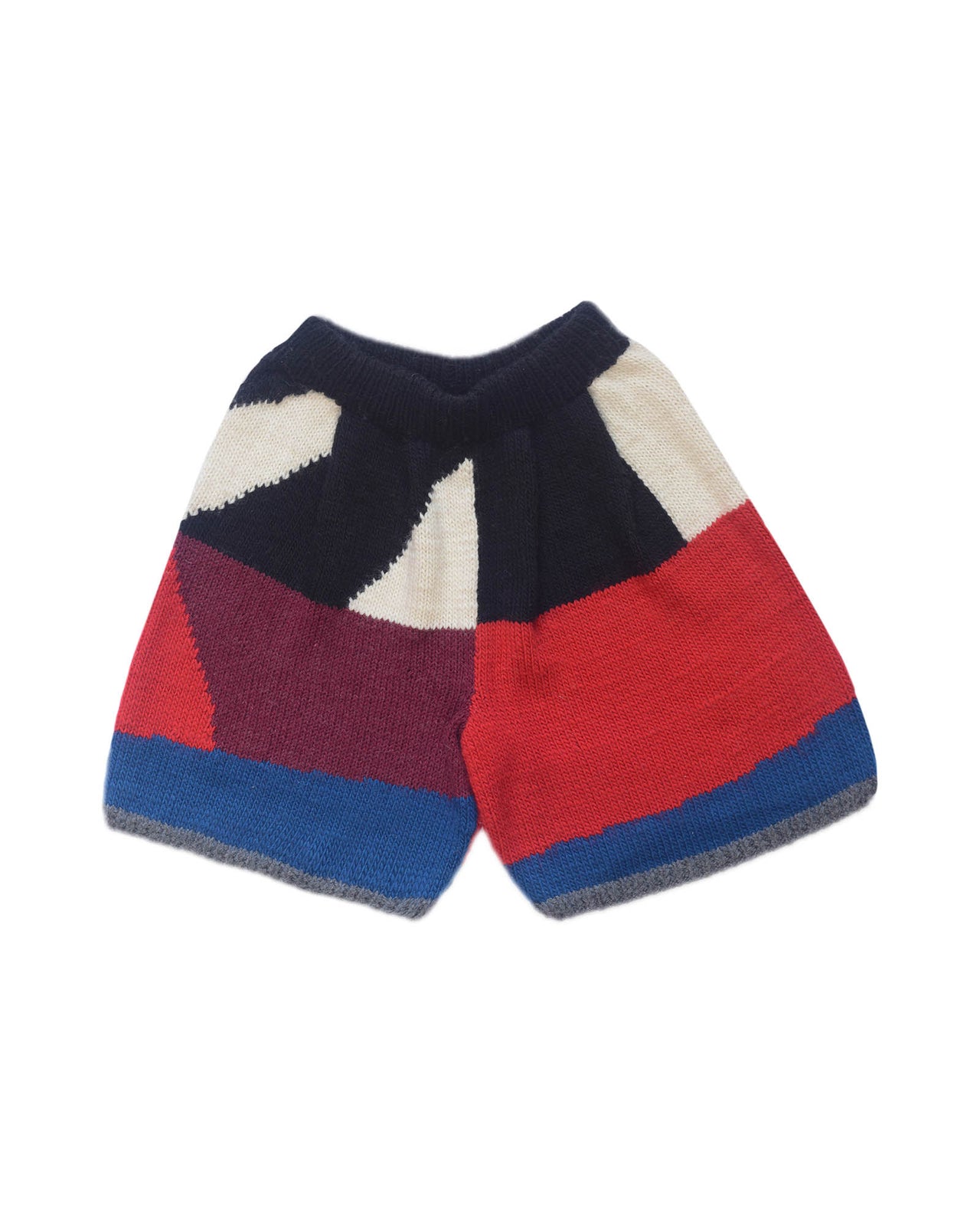 wool bermuda shorts layed flat on white background. Black, white, bordeau, red and blue colour block pattern omn the shorts. 