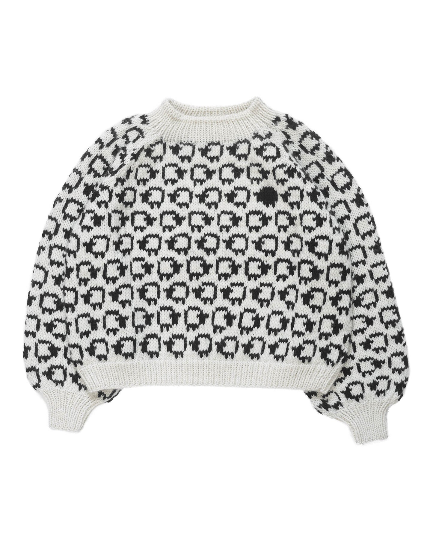 White wool sweater layed flat on white background. On the sweater is a herd of white sheep going left to right all around and a single black sheep on the front. 