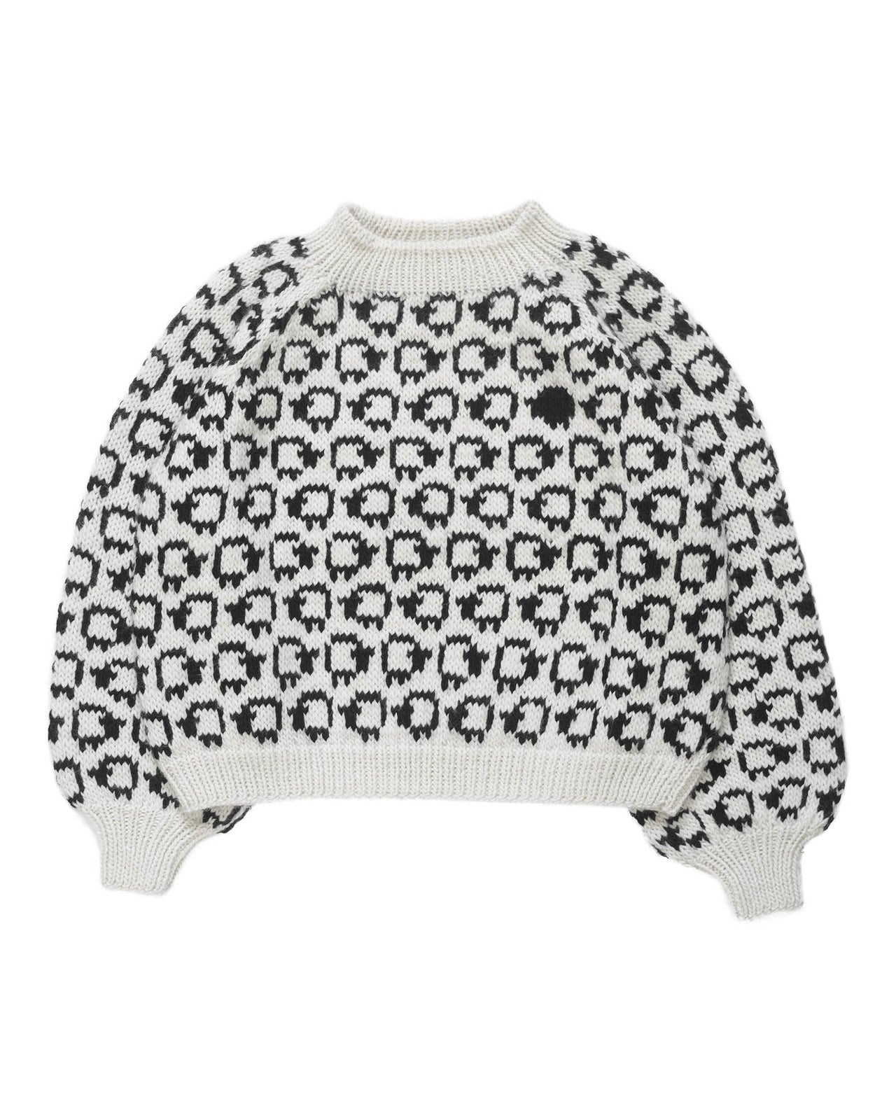 White wool sweater layed flat on white background. On the sweater is a herd of white sheep going left to right all around and a single black sheep on the front. 